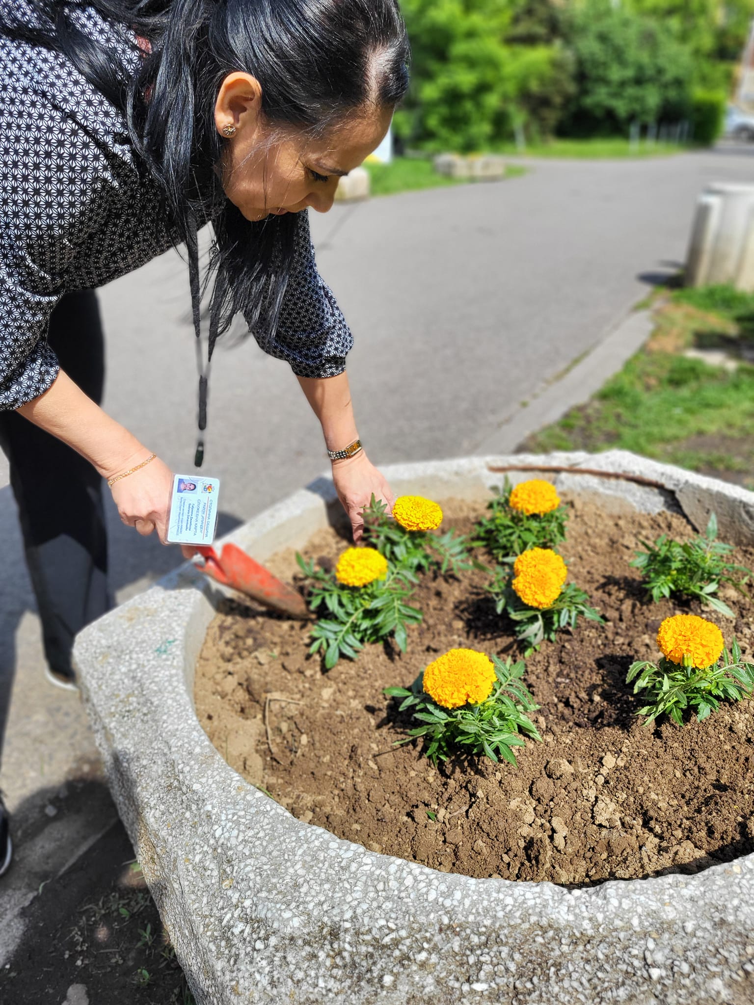 мъж в синя тениска с кръгло деколте и черни шорти, стоящ до кафява дървена стена по време на